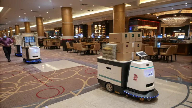 Multiple autonomous robots coordinating logistics operations in casino facility